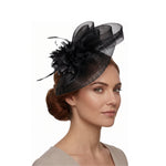 Black pillbox fascinator with central flower, feather accents, and netting veil on a black headband on model photoshoot